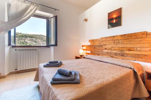 een slaapkamer met een groot bed en handdoeken bij Ristoro Norghio in Irgoli