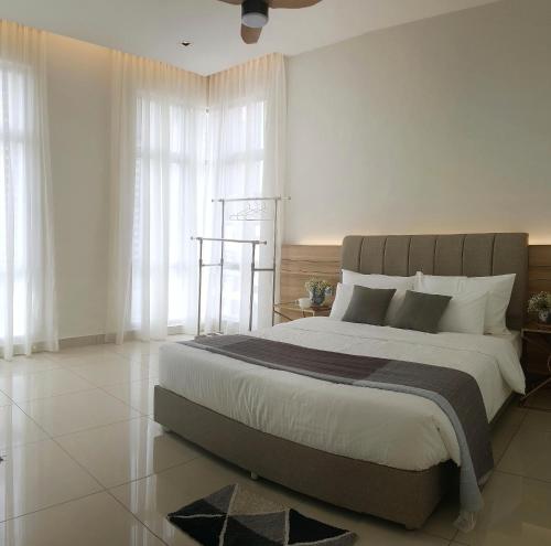 Schlafzimmer mit einem großen Bett mit weißen Wänden und Fenstern in der Unterkunft SkyHabitat Johor Bahru Town City Square in Johor Bahru