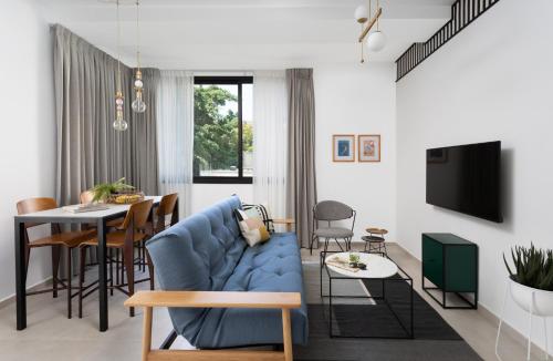 a living room with a blue couch and a table at Mr. Ben Yehuda - By TLV2GO in Tel Aviv