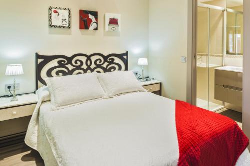 a bedroom with a large white bed and a mirror at Casa Ríos in Biescas