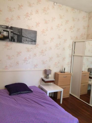 een slaapkamer met een paars bed en een spiegel bij Chambres Levadoux in Châtel-Guyon