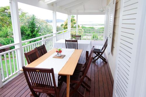 a porch with a wooden table and chairs on a balcony at Beside Still Waters in Wilderness
