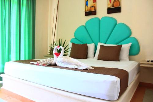 Un dormitorio con una cama grande con dos pájaros. en Beach Balance, en Playa del Carmen