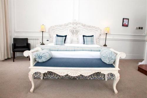 a bedroom with a white bed with blue pillows at Aston Hall Hotel, BW Signature Collection in Sheffield