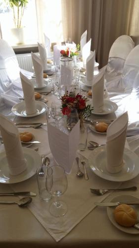 una mesa con platos blancos y servilletas. en Gasthof Manhalter, en Pitten
