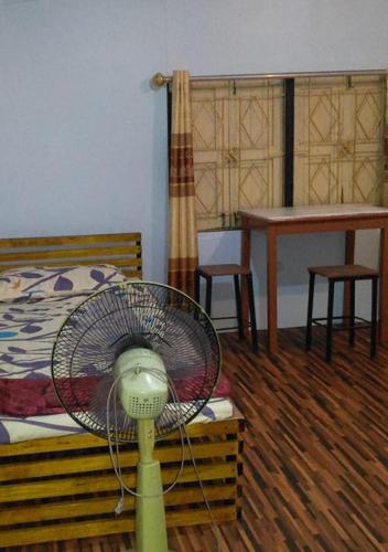 a fan in a room next to a bed at The Kong in Bangkok