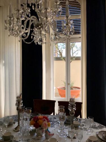 a dining room table with a chandelier and a window at Palazzina Mori - Luxury B&B in San Donà di Piave