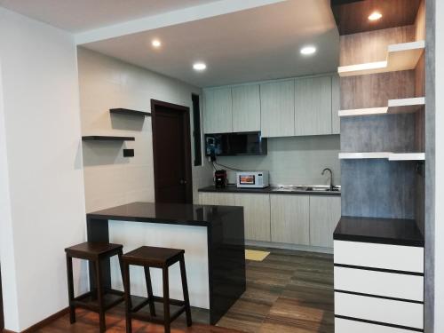 a kitchen with a counter and two stools at Vivacity jazz suite 3 condo 139 in Kuching