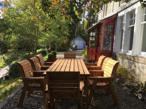 a wooden table and chairs next to a building at Netherwood House in Newtonmore