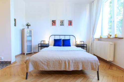 a bedroom with a large bed with blue pillows at Rental Apartments Bednarska in Warsaw