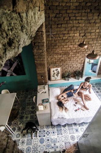 a man and a woman sitting on a bed in a room at Moonshine Boutique Hostal in Cali