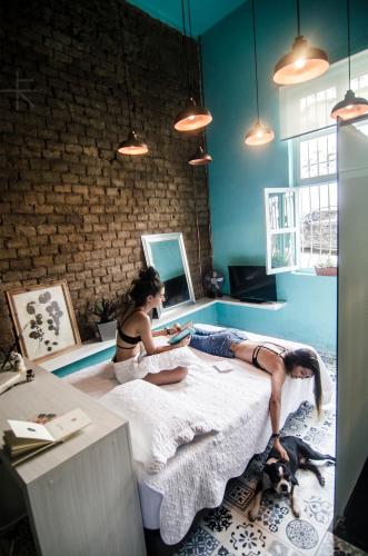 two women sitting on a bed in a room at Moonshine Boutique Hostal in Cali