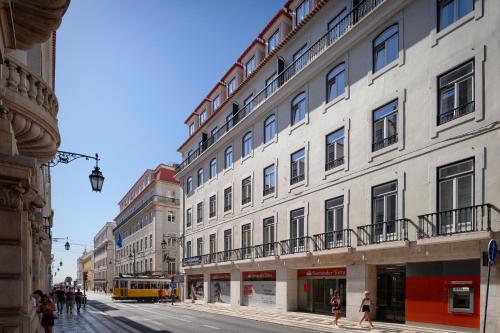 a group of buildings on a city street with a bus at Ouro Grand by Level Residences in Lisbon
