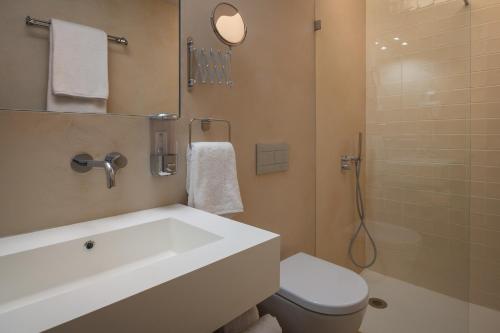 a bathroom with a sink and a toilet and a shower at Ouro Grand by Level Residences in Lisbon