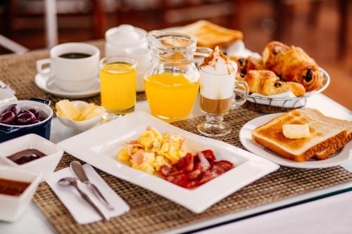 a breakfast tray with breakfast foods and drinks on a table at Daniel's Apart Hotel in Lima