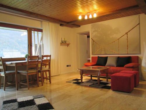 a living room with a red couch and a table at Ferienwohnung Edi Fischer in Oberfell