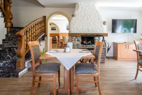 uma sala de jantar com uma mesa e cadeiras e uma lareira em Hotel Garni Brunnthaler em Garmisch-Partenkirchen