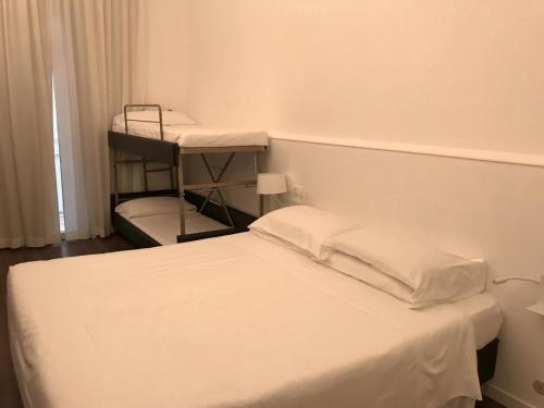 een slaapkamer met een bed en 2 stapelbedden bij Hotel Principe di Piemonte in Rimini