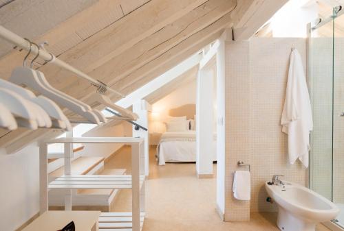 Un baño con lavabo, inodoro y una cama. en Loft con gran terraza en primera linea de playa, en Málaga