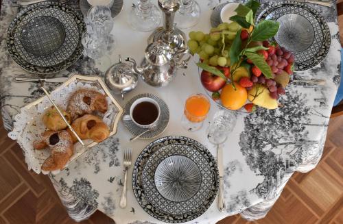 a table with plates of food and fruit on it at Palazzina Mori - Luxury B&B in San Donà di Piave