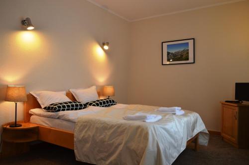 a hotel room with a bed with two towels on it at Horizont Dobrinishte in Dobrinishte
