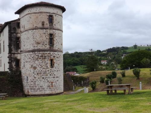 an old stone tower with a picnic table in a field at Galerie d'art d'une ancienne mairie de 1783 in Espelette