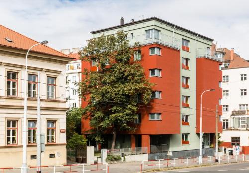 a red building with a tree in front of it at Penzion Palouček in Prague