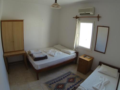 a small bedroom with two beds and a window at Merhaba Pansiyon in Bodrum City
