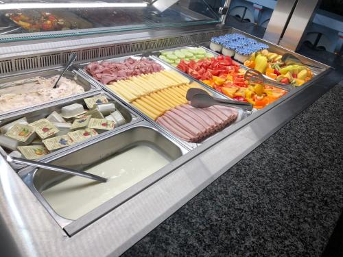 a display case filled with different types of food at Hotel Na Dolině in Frenštát pod Radhoštěm