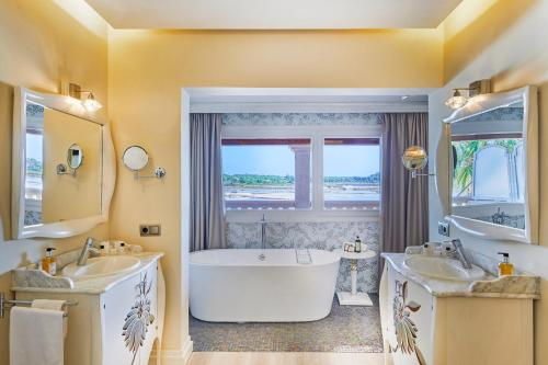 a large bathroom with two sinks and a tub at Boutiquehotel El Coto in Colonia Sant Jordi