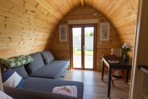 a living room with a couch and a table at Blackwater Eco Pods in Villierstown