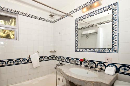 a bathroom with a sink and a tub and a mirror at Presa di Goa - Managed by Smith and Appy in Calangute