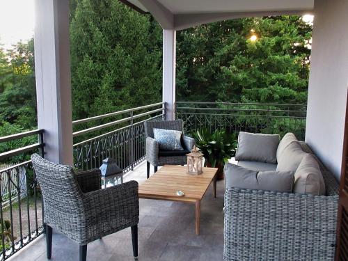 a porch with a couch and two chairs and a table at Le Bricolle in Viggiù