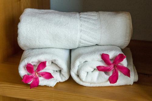 two towels with flowers on them on a table at Hubertus Hof Landhotel in Balatonfenyves