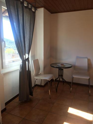 a room with a table and two chairs and a window at Albergo Ristorante Belcantone in Novaggio