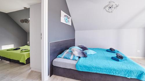 a bedroom with a bed with a blue blanket at Apartament Perła Pienin in Dębno