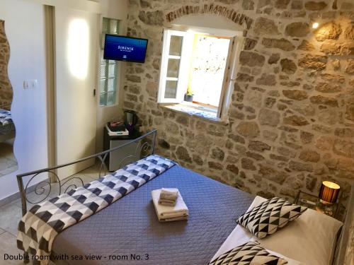 a bedroom with a bed in a stone wall at City Rooms Šibenik in Šibenik