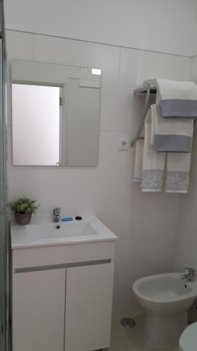 Baño blanco con lavabo y aseo en Crisapartment en Lisboa