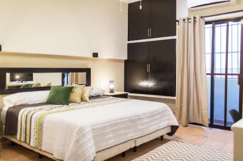 Un dormitorio con una cama grande y una ventana grande en Departamento familiar, en Playa del Carmen