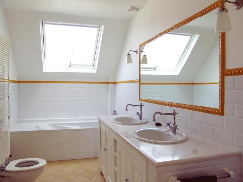La salle de bains est pourvue de 2 lavabos, d'une baignoire et d'un miroir. dans l'établissement Louise Chatelain suites, à Bruxelles