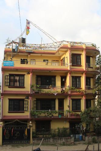 un bâtiment jaune avec une grue en haut dans l'établissement Monkey Temple Homestay, à Katmandou