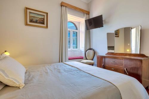 a bedroom with a bed and a dresser and a mirror at Century House with private pool by HR Madeira in Funchal