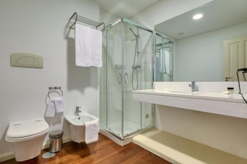 a bathroom with a shower and a toilet and a sink at Century House with private pool by HR Madeira in Funchal