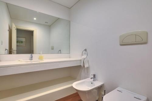 a white bathroom with a sink and a toilet at Century House with private pool by HR Madeira in Funchal