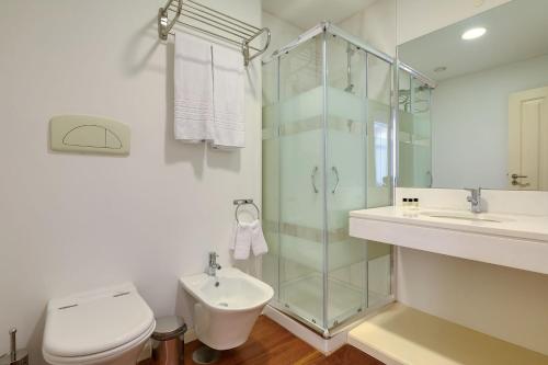 een badkamer met een douche, een toilet en een wastafel bij Century House with private pool by HR Madeira in Funchal