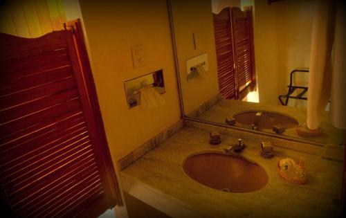a bathroom with a sink and a large mirror at Hotel Piedras de Sol Solaris Morelos in Tlaltizapán