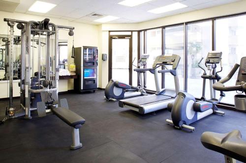 a gym with several treadmills and machines in a room at Skyline Island Colony Hotel in Honolulu
