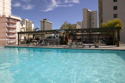 a large swimming pool in the middle of a city at Skyline Island Colony Hotel in Honolulu