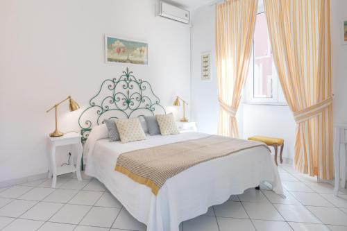 ein weißes Schlafzimmer mit einem großen Bett und einem Fenster in der Unterkunft B&B Piazza Fratti in Civitavecchia