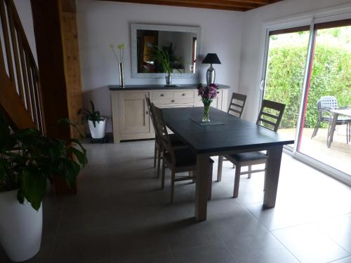 a dining room with a black table and chairs at Welcome in Guécélard